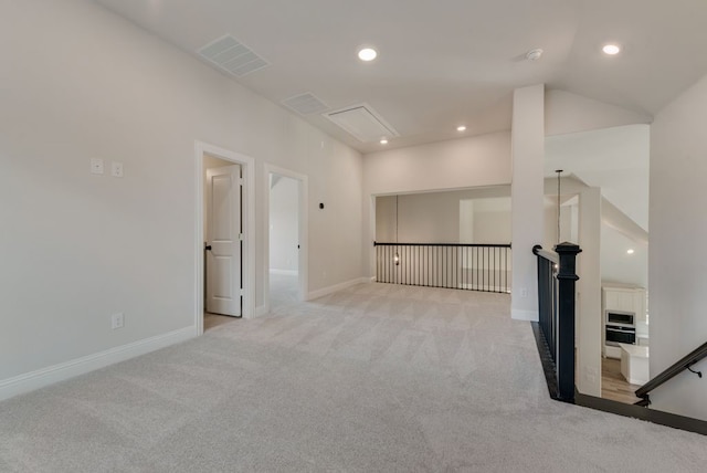 carpeted empty room with visible vents, recessed lighting, lofted ceiling, and baseboards