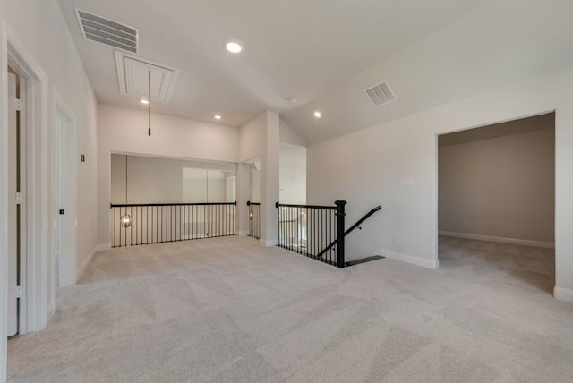 carpeted empty room featuring recessed lighting, visible vents, lofted ceiling, and attic access