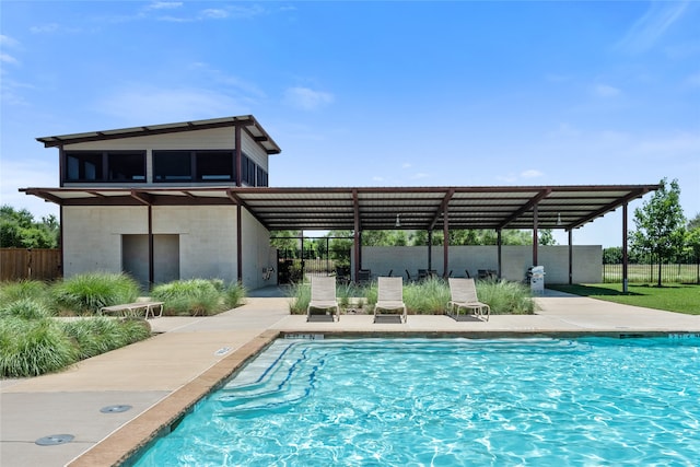 pool with a patio and fence