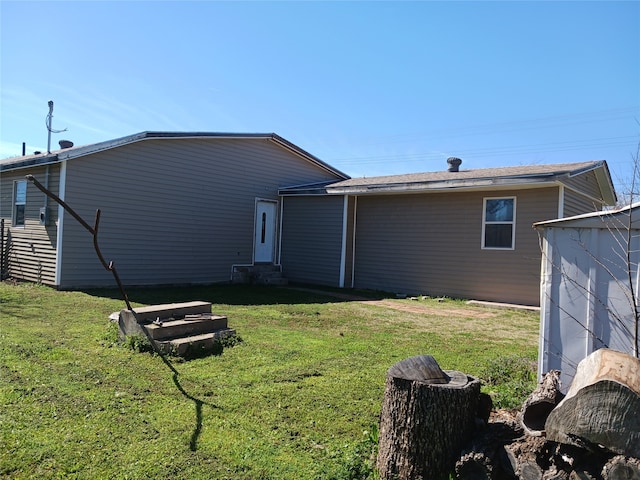 rear view of property featuring a lawn