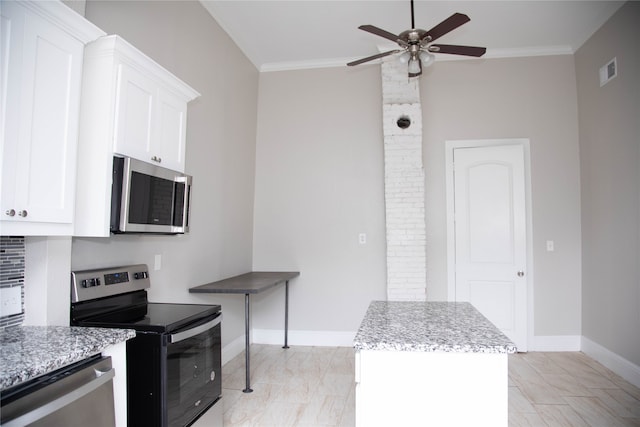 kitchen featuring light stone countertops, ceiling fan, stainless steel appliances, white cabinetry, and ornamental molding