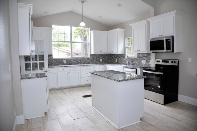 kitchen with a kitchen island, tasteful backsplash, stainless steel appliances, and plenty of natural light