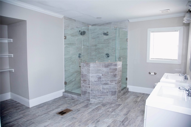 bathroom with ornamental molding, a shower with shower door, and dual bowl vanity