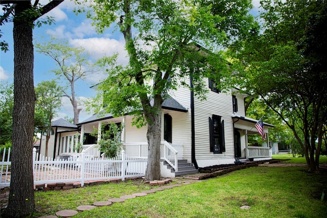 view of front of home featuring covered porch and a front lawn