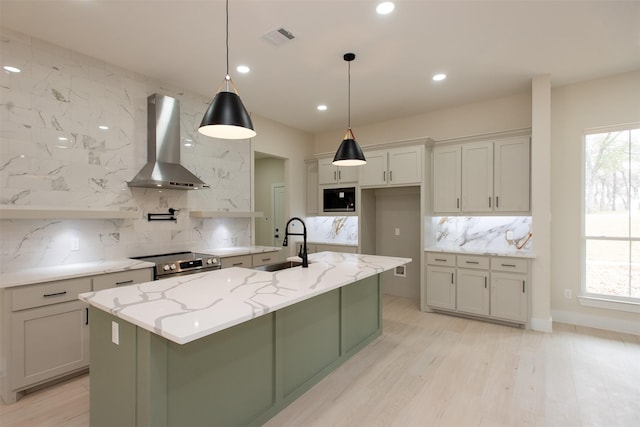 kitchen with visible vents, a sink, built in microwave, wall chimney range hood, and stainless steel electric range oven