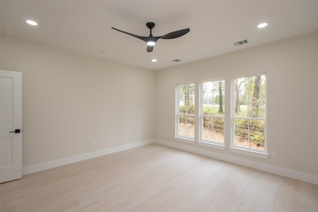 unfurnished room featuring baseboards, visible vents, light wood finished floors, and ceiling fan