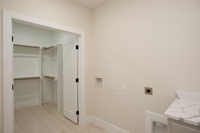 laundry area with electric dryer hookup, light wood finished floors, baseboards, hookup for a washing machine, and laundry area