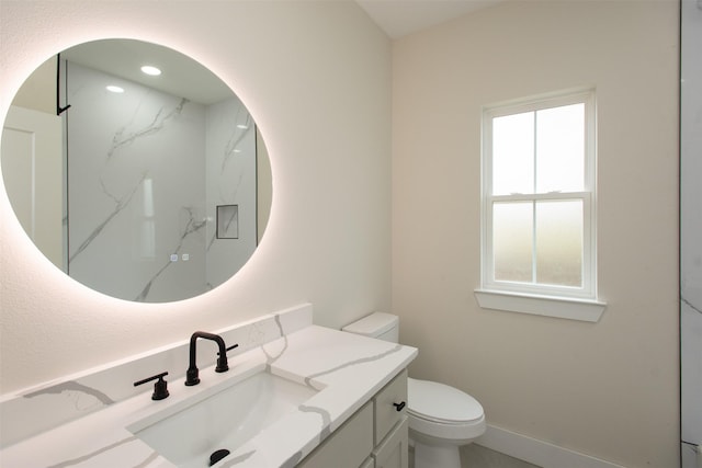 bathroom with vanity, toilet, and baseboards