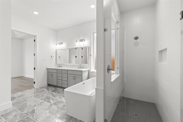 bathroom with separate shower and tub and vanity