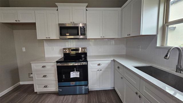 kitchen with white cabinets, dark hardwood / wood-style flooring, backsplash, stainless steel appliances, and sink