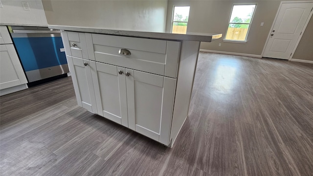 kitchen featuring white cabinets, dark hardwood / wood-style floors, and stainless steel dishwasher