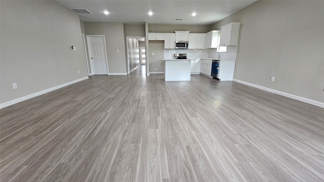 unfurnished living room with hardwood / wood-style flooring and sink