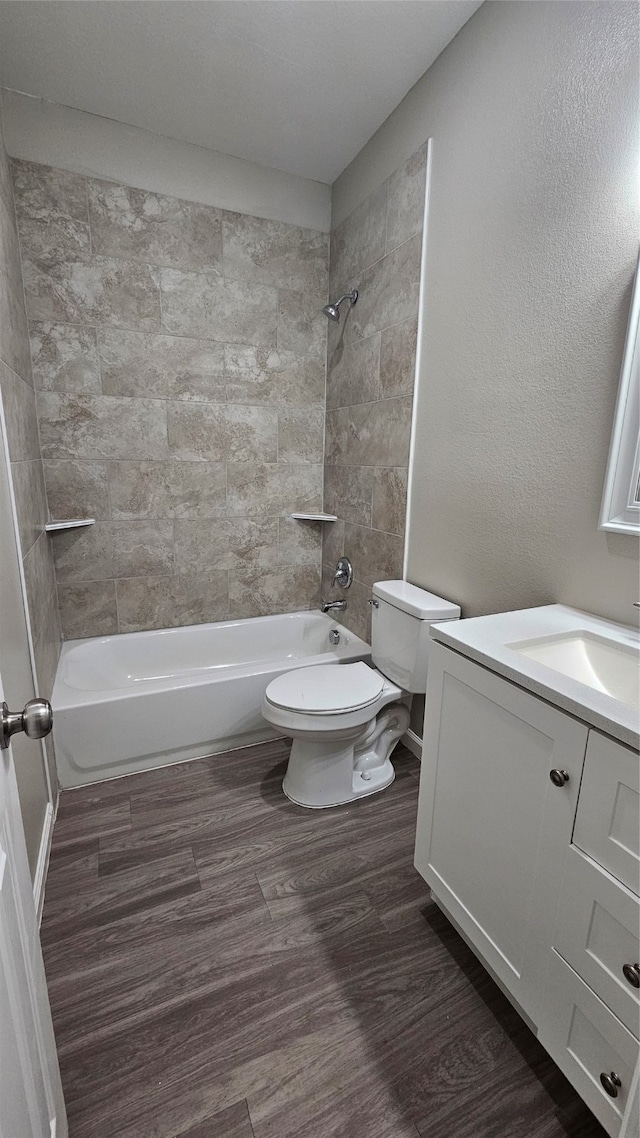 full bathroom with tiled shower / bath, wood-type flooring, toilet, and vanity