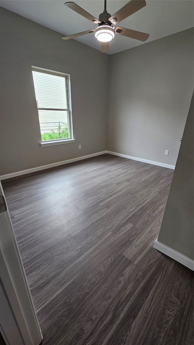 empty room featuring dark wood-type flooring and ceiling fan