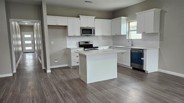 kitchen featuring white cabinets, dark hardwood / wood-style flooring, a kitchen island, and stainless steel appliances