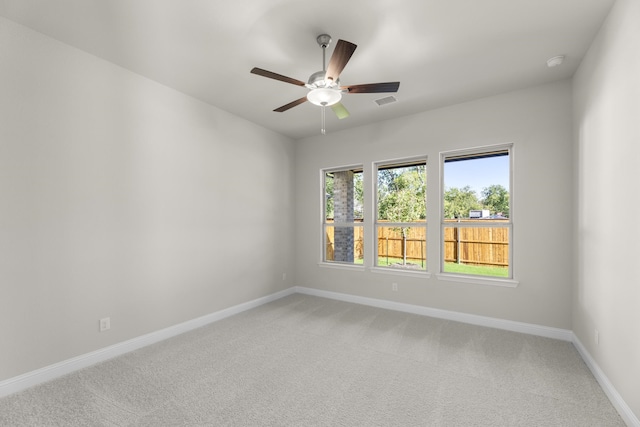 carpeted spare room with ceiling fan