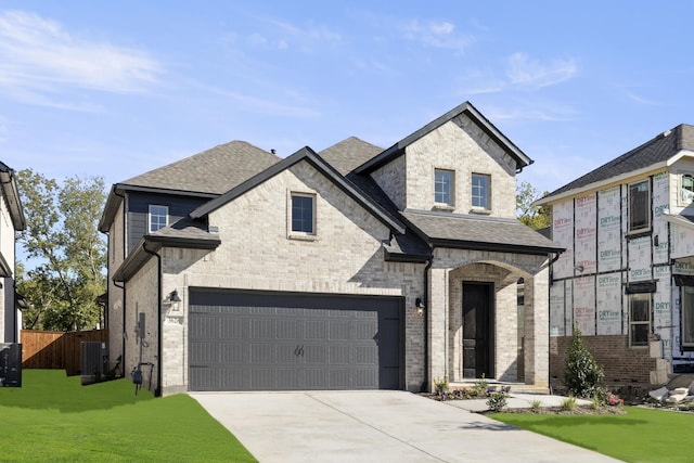 view of front of house with a front lawn, a garage, and cooling unit