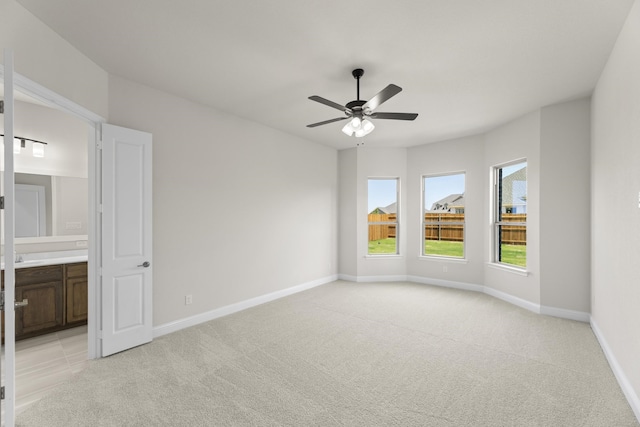 unfurnished room with light colored carpet and ceiling fan