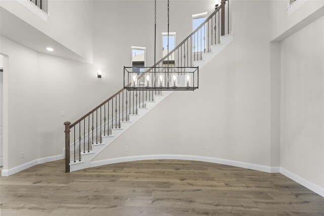 staircase featuring hardwood / wood-style floors and a towering ceiling