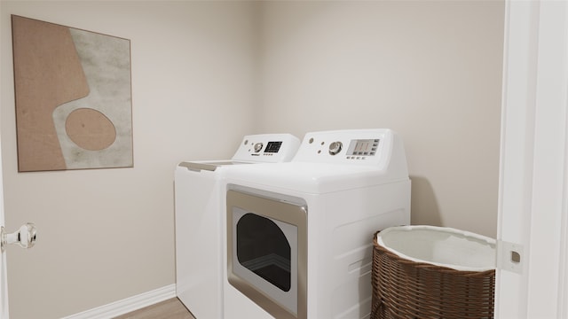 laundry area featuring independent washer and dryer and hardwood / wood-style floors