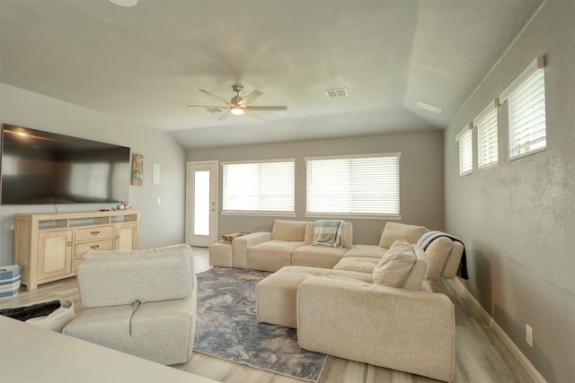 living room featuring a healthy amount of sunlight, light hardwood / wood-style floors, and ceiling fan