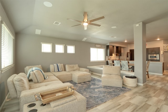 living room featuring lofted ceiling, ceiling fan, and light wood-type flooring