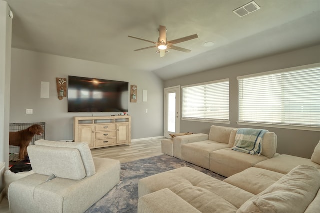 living room featuring ceiling fan, vaulted ceiling, and light wood-type flooring