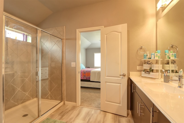 bathroom with an enclosed shower, large vanity, hardwood / wood-style floors, and lofted ceiling