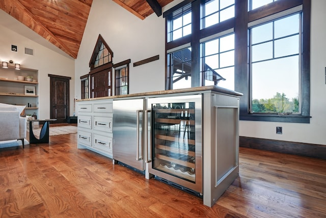 interior space featuring wine cooler, light wood-type flooring, high vaulted ceiling, and wood ceiling