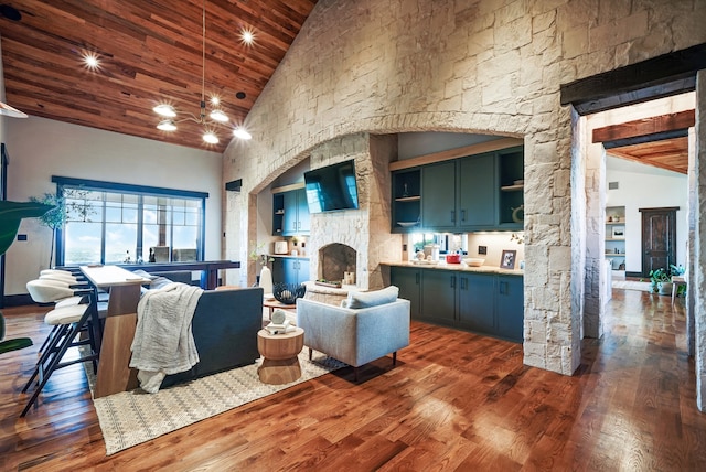 living room with high vaulted ceiling, wooden ceiling, and dark hardwood / wood-style floors