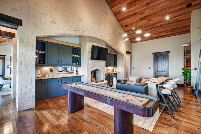 interior space with hardwood / wood-style flooring, wood ceiling, high vaulted ceiling, and a fireplace