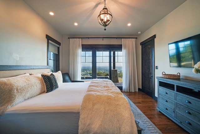 bedroom with dark hardwood / wood-style flooring and a chandelier