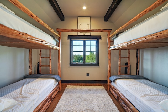 bedroom with lofted ceiling with beams and dark hardwood / wood-style floors