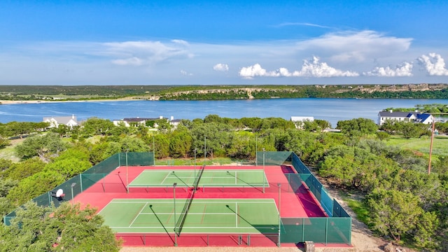 view of tennis court with a water view