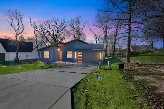 view of front of house featuring a garage and a yard