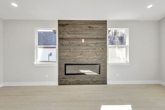 unfurnished living room with light hardwood / wood-style flooring and a large fireplace