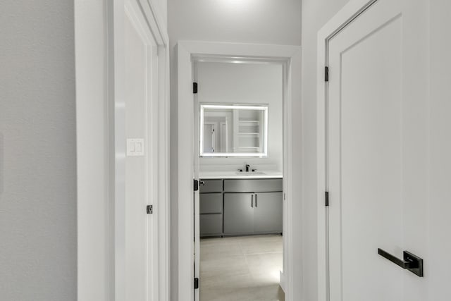 corridor with sink and light tile patterned flooring