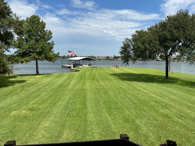 view of yard with a boat dock and a water view