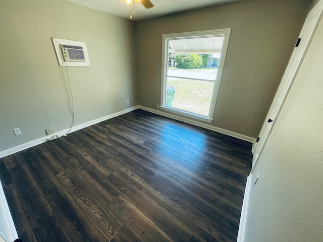 spare room featuring dark hardwood / wood-style flooring, ceiling fan, and a wall mounted air conditioner