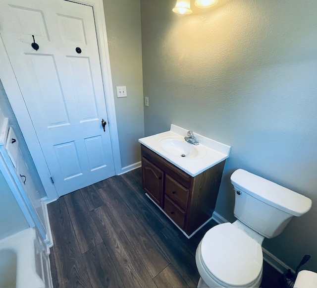 bathroom with wood-type flooring, vanity, and toilet