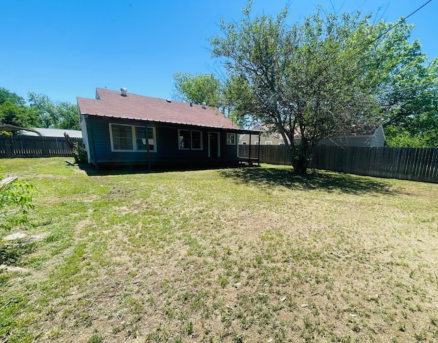 rear view of property featuring a yard