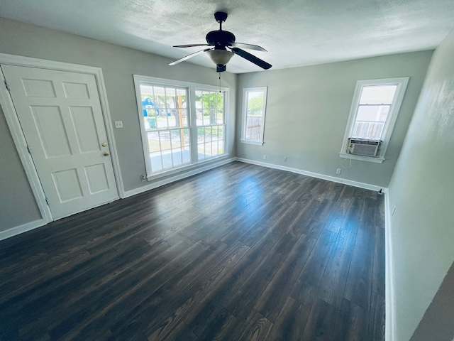 empty room with dark hardwood / wood-style floors, ceiling fan, and a textured ceiling