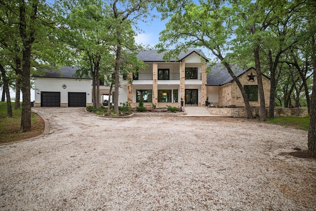 view of front of house with driveway, stone siding, and a garage