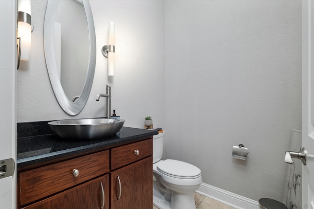 half bath featuring vanity, toilet, and tile patterned floors