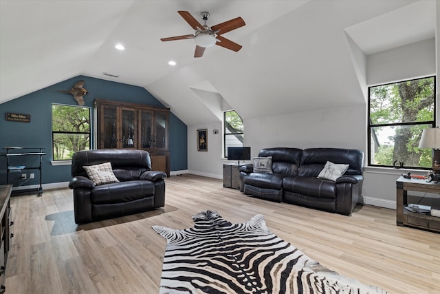 living area featuring lofted ceiling, a wealth of natural light, wood finished floors, and visible vents