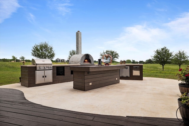 wooden deck with exterior kitchen, a patio, and grilling area