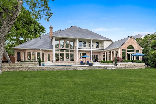 back of house with a lawn and a patio area