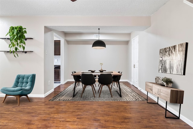 dining space with a textured ceiling and wood-type flooring