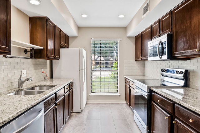 kitchen with light tile patterned floors, appliances with stainless steel finishes, and decorative backsplash