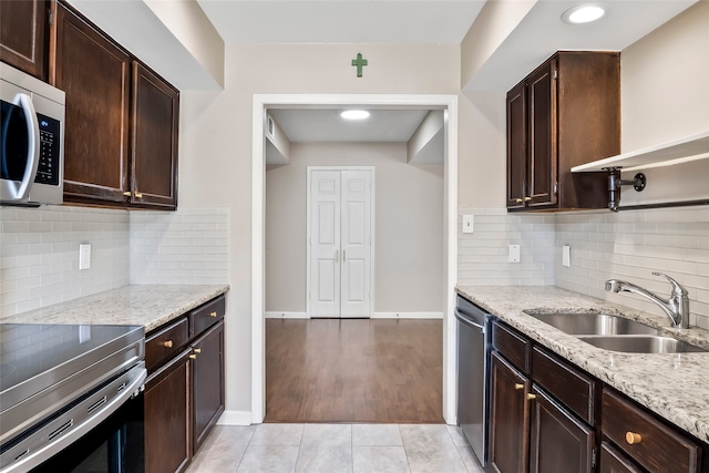 kitchen with sink, tasteful backsplash, light hardwood / wood-style floors, and stainless steel appliances